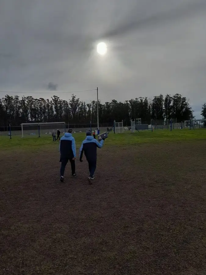 Integrantes del cuerpo técnico caminando hacia la cancha antes de un partido